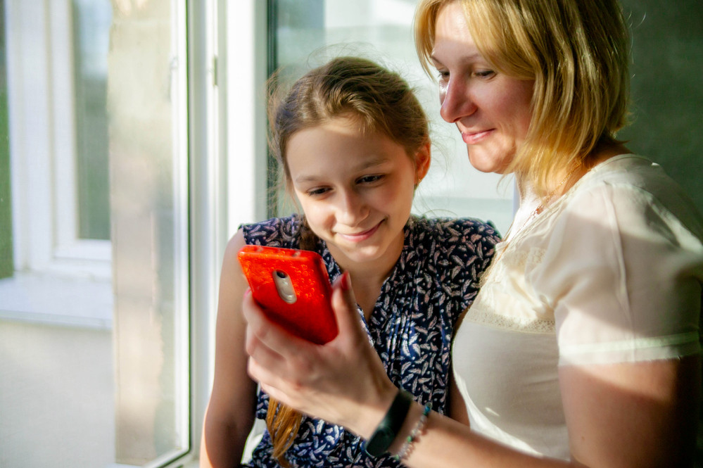 Parent teaching child to use messaging app responsibly